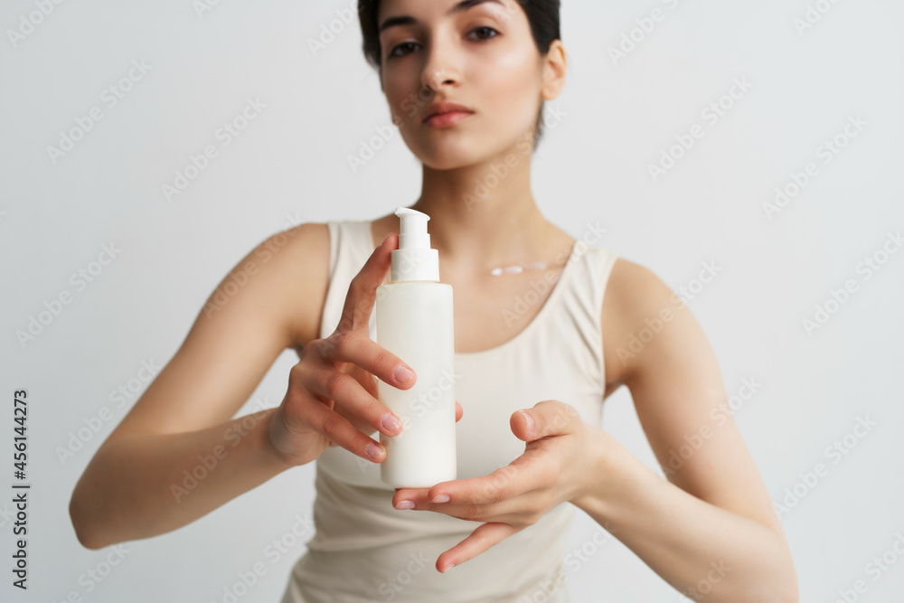 woman with a jar of lotion in her hands in a white t-shirt skin care spa treatments