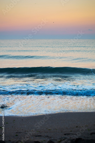 The waves of the sea touch the sand. Sunrises and sunsets at sea. Vacation, travel - concept.