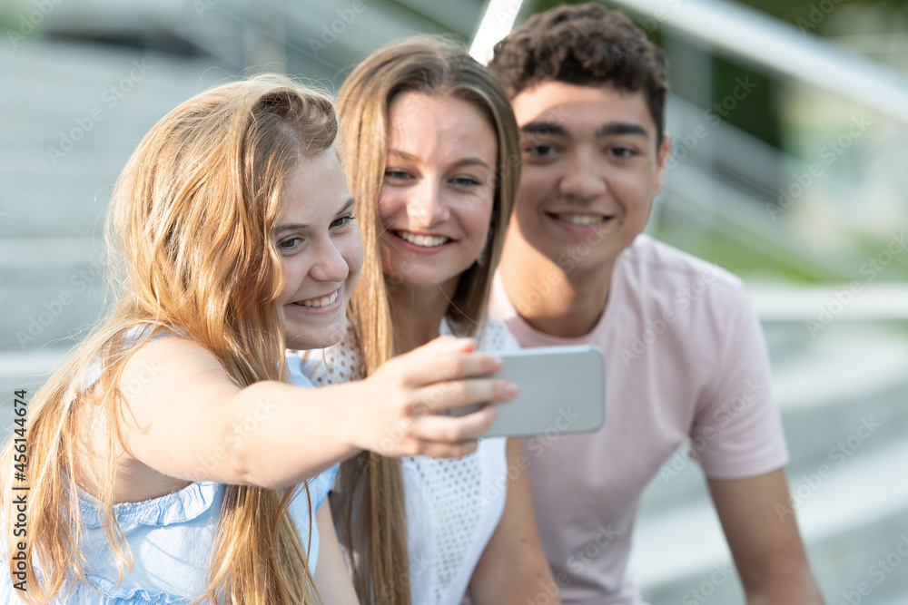 Happy teenager friends taking a selfie sitting on stairs. Happy teenager friends taking a selfie sitting on stairs.