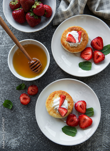 Cottage cheese pancakes  ricotta fritters on ceramic plate with  fresh strawberry.