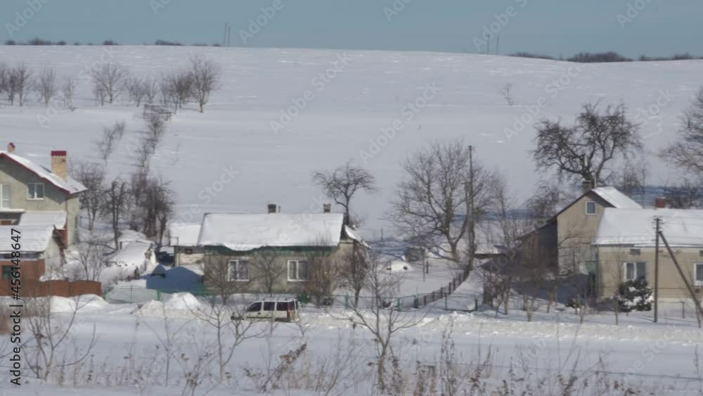 the car goes through the village in winter,a car rides on a snowy road in the countryside the car goes through the village in winter,a car rides on a snowy road in the countryside
