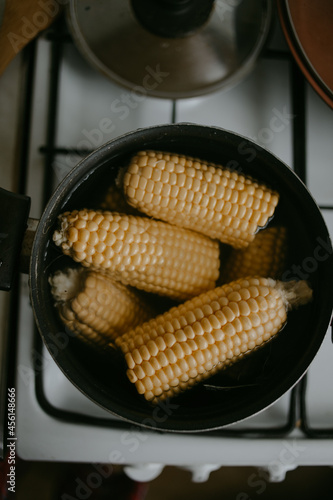 cooking the corn at the saucepan on the kitchen