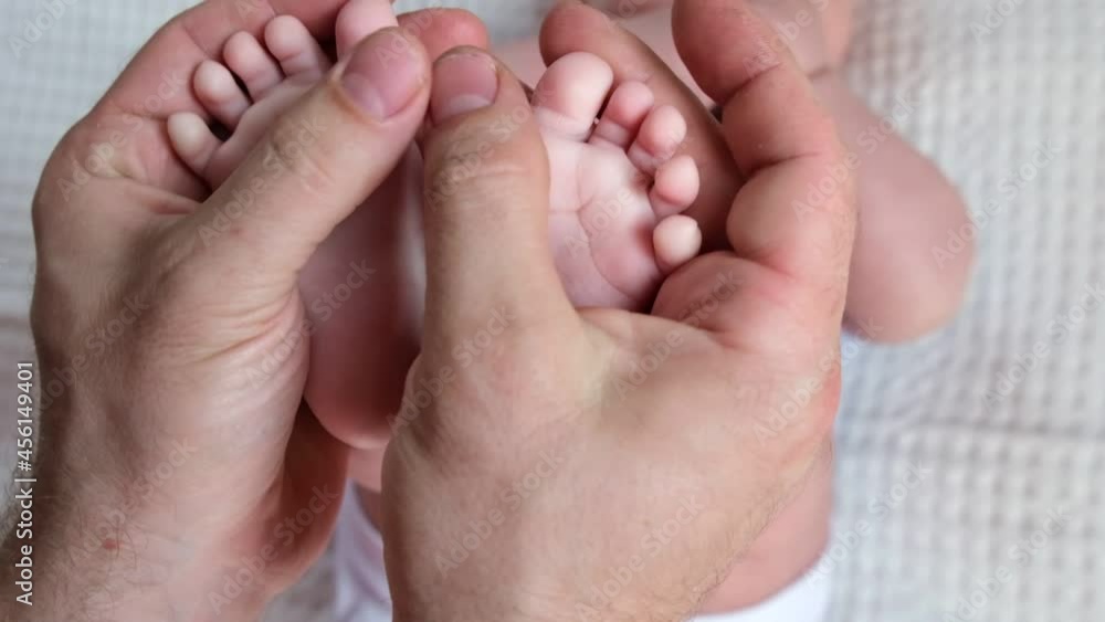 Father holding Baby Feet in Hands. Legs Newborn in male parents Hand. Small children's Feet in the Father's Palm. Close-up. Little Toes of Child and Man Hands of Happy Parent. Father's Day Holiday. Father holding Baby Feet in Hands. Legs Newborn in male parents Hand. Small children's Feet in the Father's Palm. Close-up. Little Toes of Child and Man Hands of Happy Parent. Father's Day Holiday.