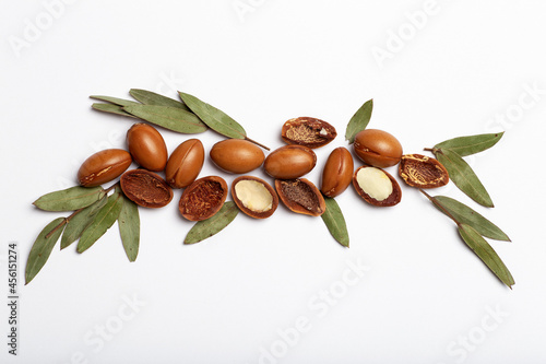 Argan seeds isolated on a white background. Argan oil nuts with plant. Cosmetics and natural oils background 