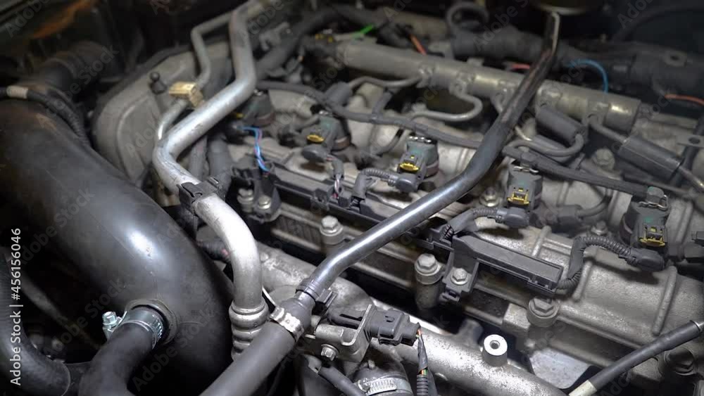 Close up view of old car engine running under artificial lights. Diesel motor. Macro shot of the inside of the car, engine from the vehicle is in car repair shop. View of smoke Close up view of old car engine running under artificial lights. Diesel motor. Macro shot of the inside of the car, engine from the vehicle is in car repair shop. View of smoke