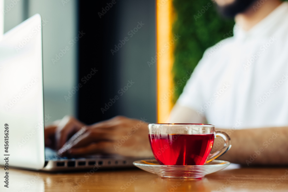successful man drinking tea and looking at a laptop sitting in a cafe, Business man having breakfast in a cafe and using a laptop successful man drinking tea and looking at a laptop sitting in a cafe, Business man having breakfast in a cafe and using a laptop