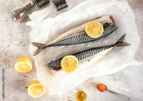 Fresh raw mackerel fish. On a gray background. Raw fish with lemon and dressings