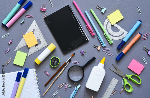 Back to school. School supplies: notebook, pen, pencil on a gray background. View from above. Office tools.