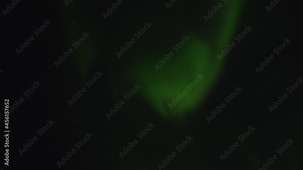 A unique natural phenomenon Aurora borealis. Moving green swirls of the northern lights in the night sky in the north A unique natural phenomenon Aurora borealis. Moving green swirls of the northern lights in the night sky in the north