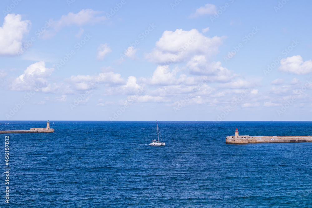 Landschaft mit Segelboot und Leuchttürmen in Valletta, Malta