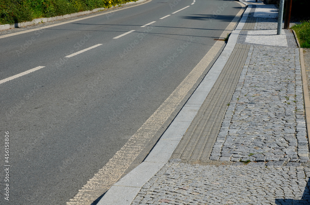 Obraz premium better safety, the cities are equipped with posts on the edge of the sidewalk with chain railing. direct pedestrians to cross the road safely. the blind have protrusions on the tiles for tactile feet