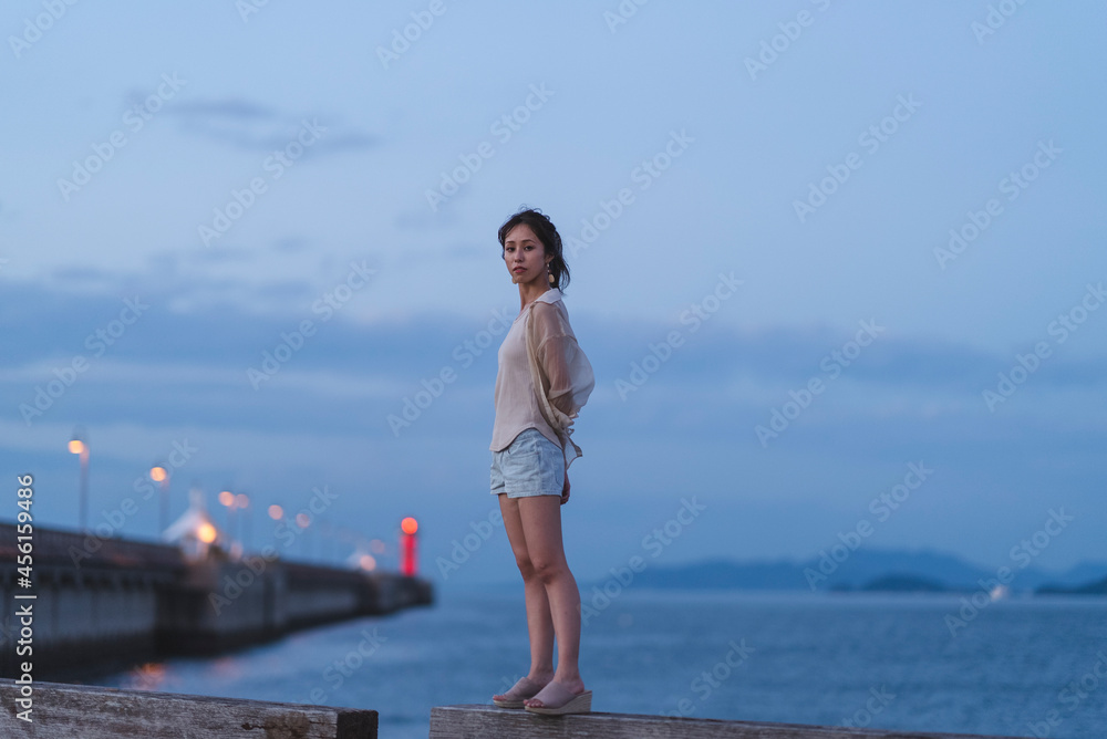 夕暮れの海岸にいる女性 夕暮れの海岸にいる女性