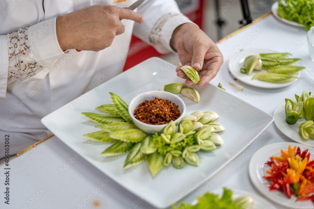 Chef carves patterns on cabbage and other vegetables and fruits for a beautiful table decoration Chef carves patterns on cabbage and other vegetables and fruits for a beautiful table decoration