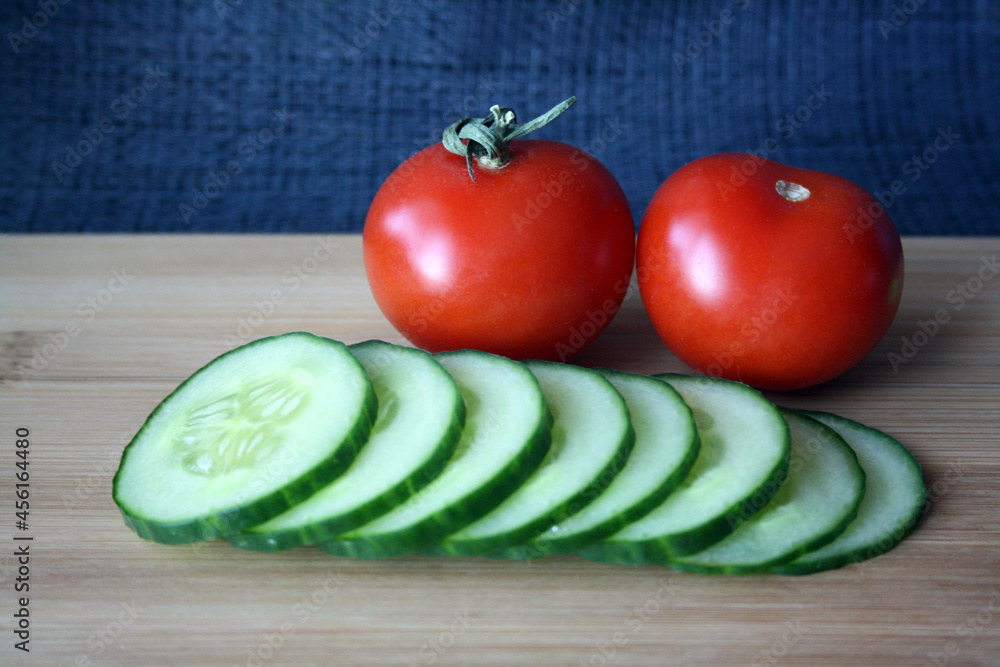 Tomatoes and cucumbers on a wooden board. Tomatoes and cucumbers on a wooden board.