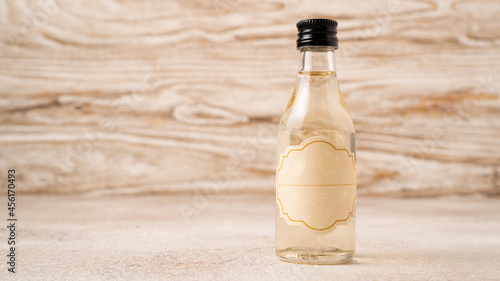 A small bottle of coffee syrup on wooden table. Coffee syrup in mini bottle