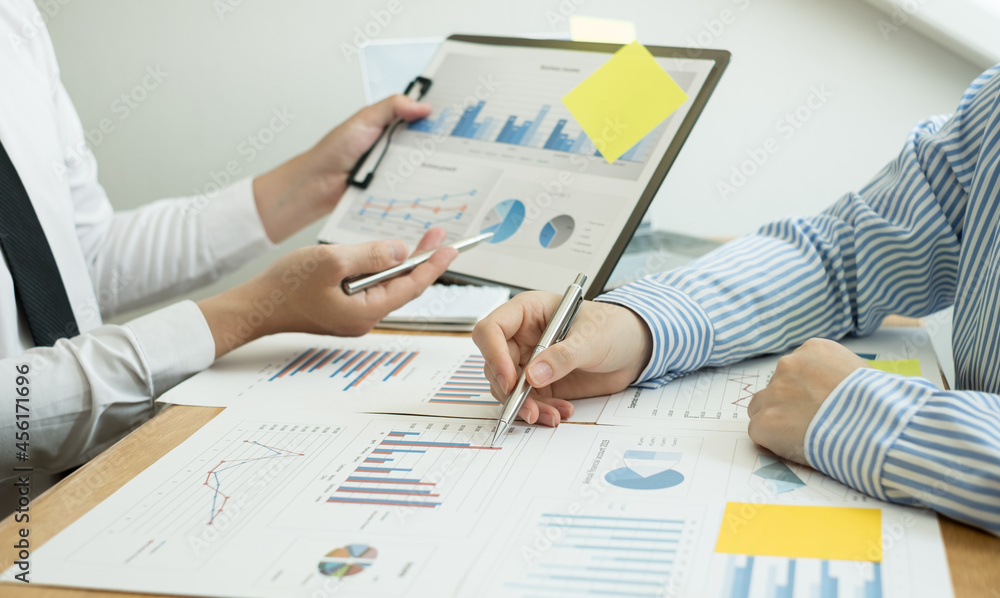 Two business leaders talk about charts, financial graphs showing results are analyzing and calculating planning strategies, business success building processes Two business leaders talk about charts, financial graphs showing results are analyzing and calculating planning strategies, business success building processes
