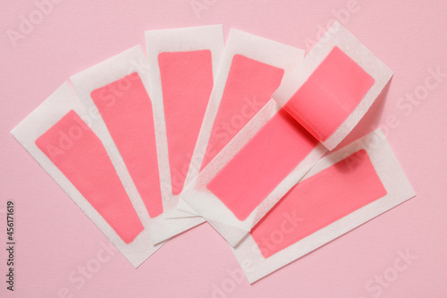 Fotografie Pink wax strips for depilation on a pink background