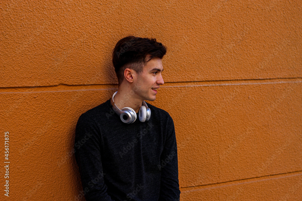 young boy waiting on an orange wall young boy waiting on an orange wall