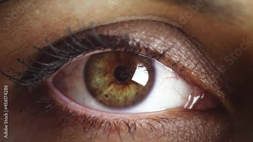 woman eye close up shot, eye opening with beautiful green brown iris and black eye pupill. Healthy eyesight concept. Front view macro video in 4K.