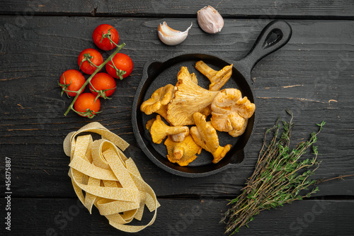 Pasta chanterelle mushrooms ingredients, on black wooden table background, top view flat lay