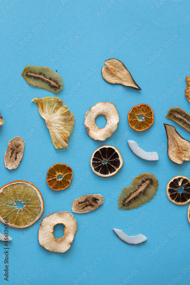Dried fruits Useful vitamins Kiwi Coconut Pear Orange Banana Mandarin Lime Colored background blue