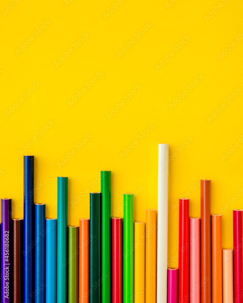 Colored pencils are arranged in a row on a light yellow background. One white pencil sticks out above all. Gradient color. Concept: development jumps, stock exchange jumps. Colored pencils are arranged in a row on a light yellow background. One white pencil sticks out above all. Gradient color. Concept: development jumps, stock exchange jumps.