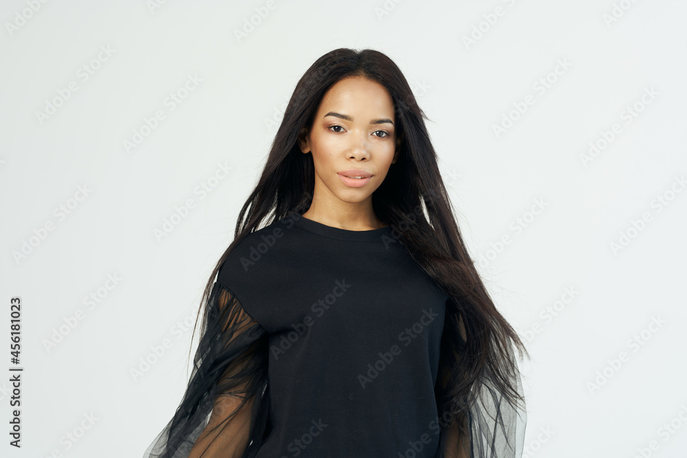 Fototapeta premium woman african appearance and long dark hair cosmetics light background
