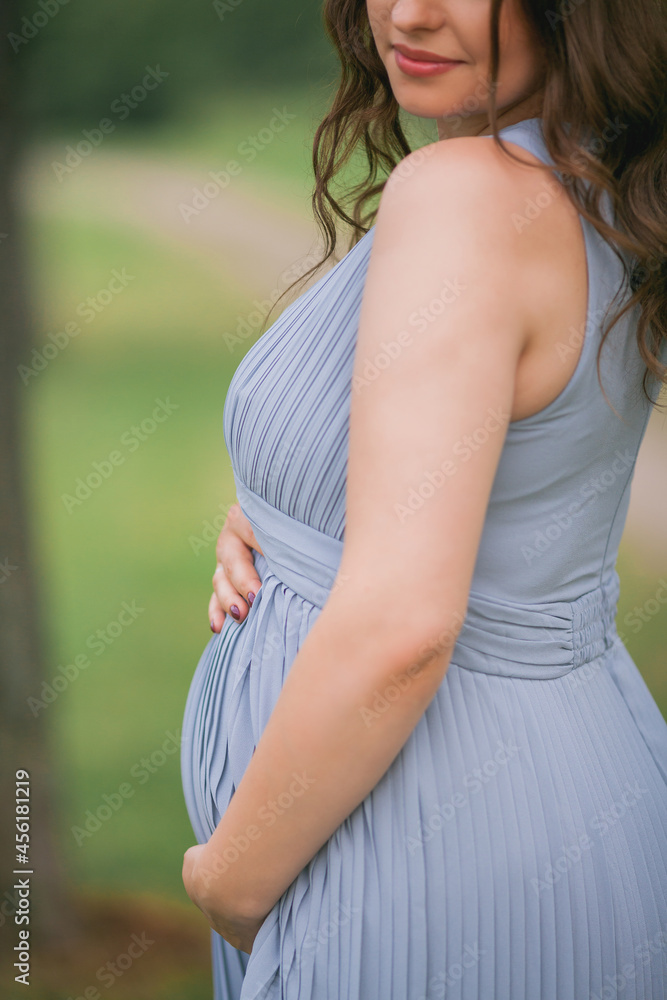 Portrait of a young pregnant woman with a wreath on her head in the park. Portrait of a young pregnant woman with a wreath on her head in the park.