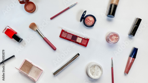 Beauty concept. Makeup products shadows, highlighter, blush, brushes, powder, glitter, mascara, gloss, lipstick, pencil on white background
