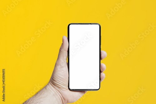 Iphone trzymany w ręce na kolorowym tle. Pusty ekran do wypełnienia
