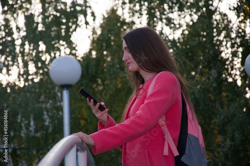 Beautiful female student browsing smartphone in park