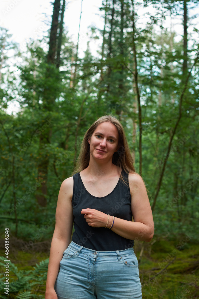 A vertical shot of a caucasian attractive female in the forest A vertical shot of a caucasian attractive female in the forest