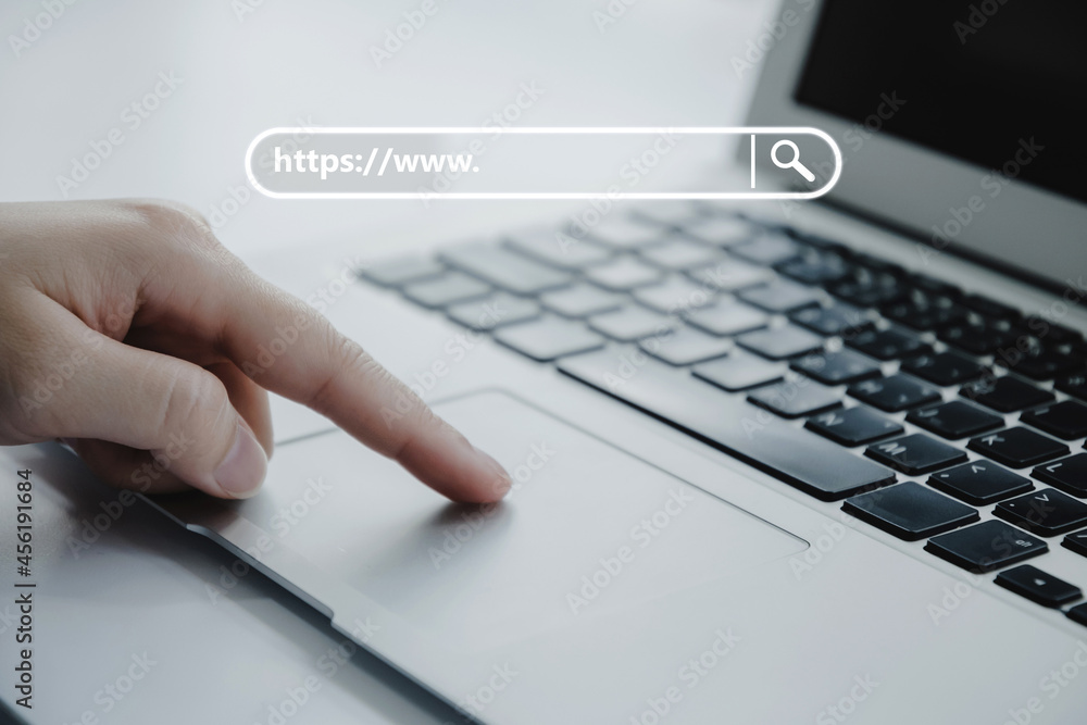 people hand touching touchpad on laptop computer with www search bar graphic on desk at home office, job search, social network, internet online, search engine, finance, digital technology concept