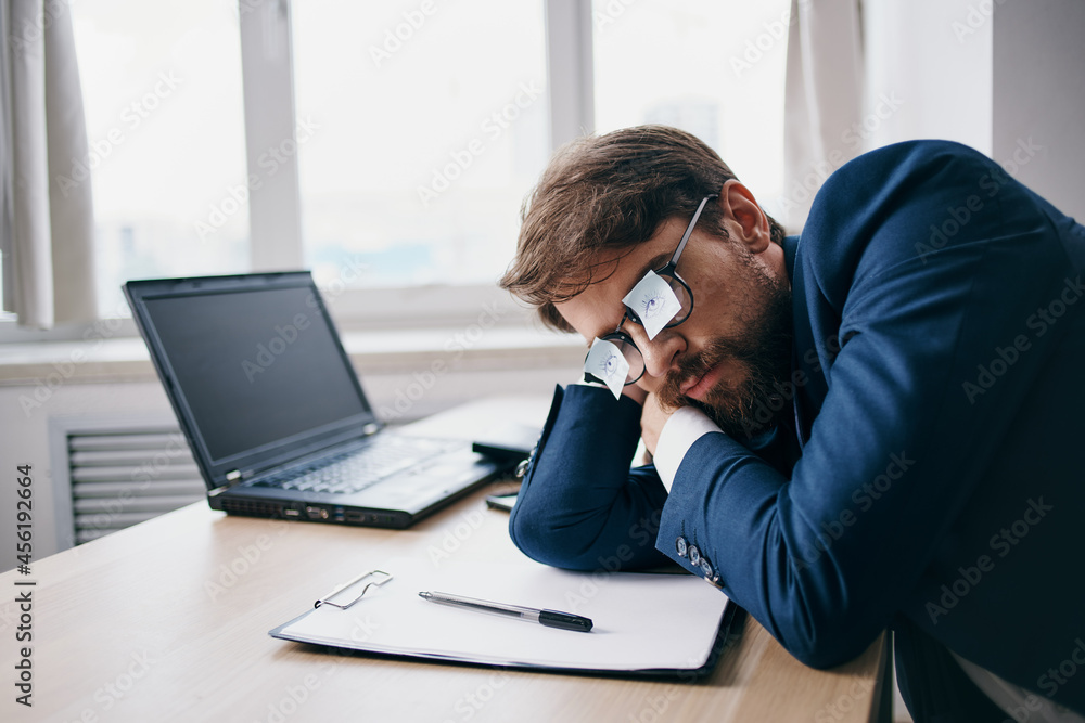 Man sitting at a desk in front of a laptop finance network official Man sitting at a desk in front of a laptop finance network official