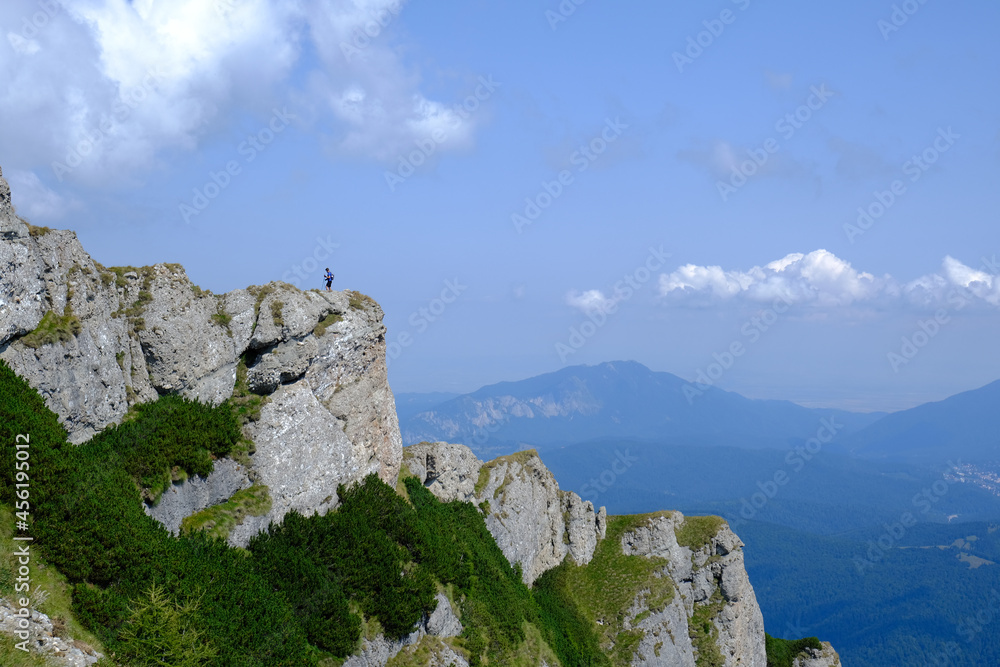 Hiking on the ridge of the amazing rocks of the Caraiman Peak, Bucegi mountains of Carpathians, Prahova, Romania