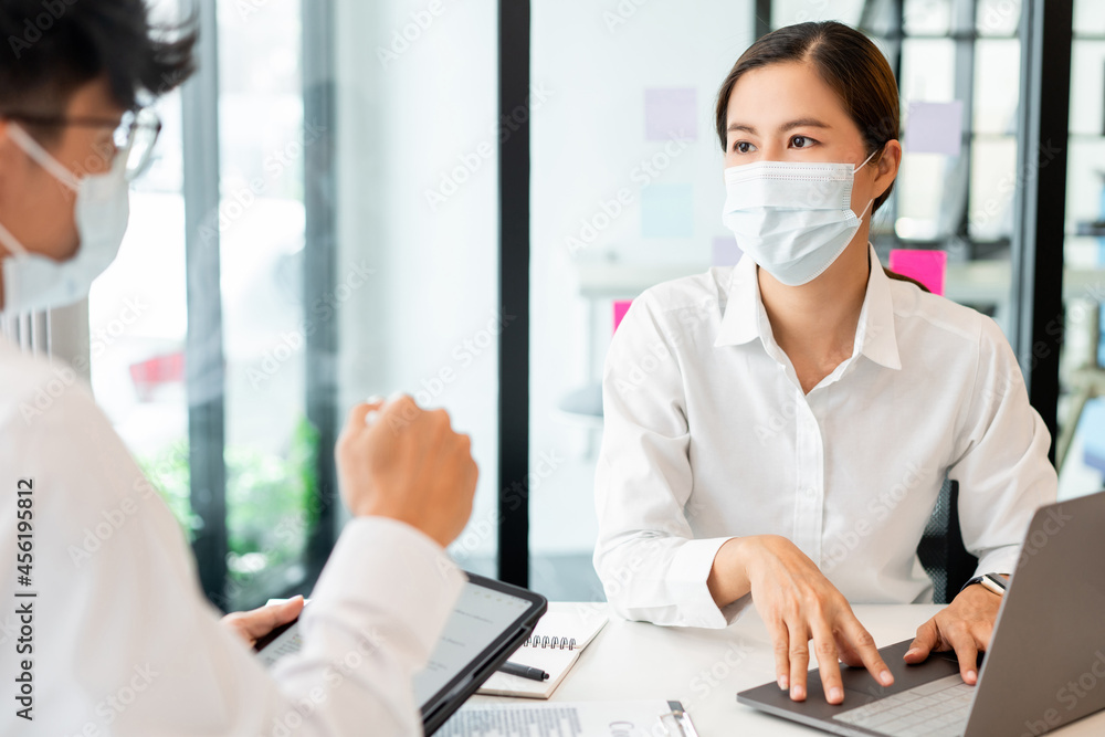 two coworkers helping each other to revise the contract before signing signature carefully with the hygienic protection two coworkers helping each other to revise the contract before signing signature carefully with the hygienic protection