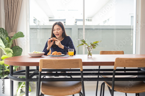 Having meal concept a smiling woman appreciating her favorite desserts on the table in a dinning room