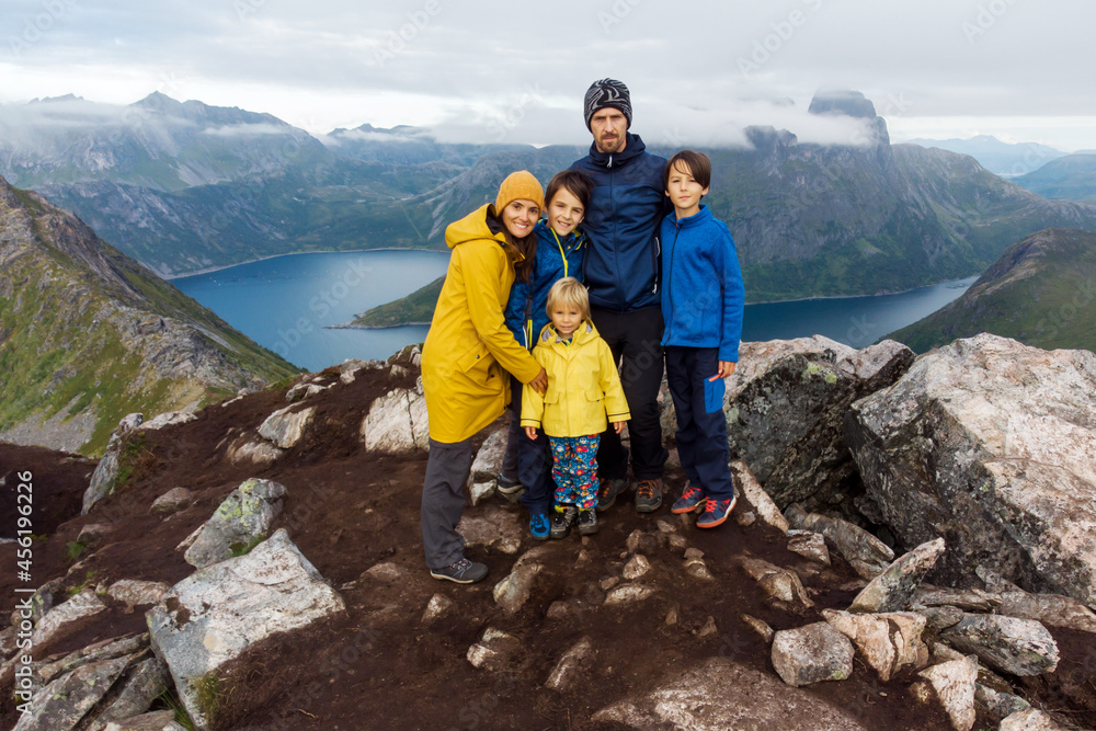 Happy family of five, looking at an amazing view over Segla mountain on Senja island