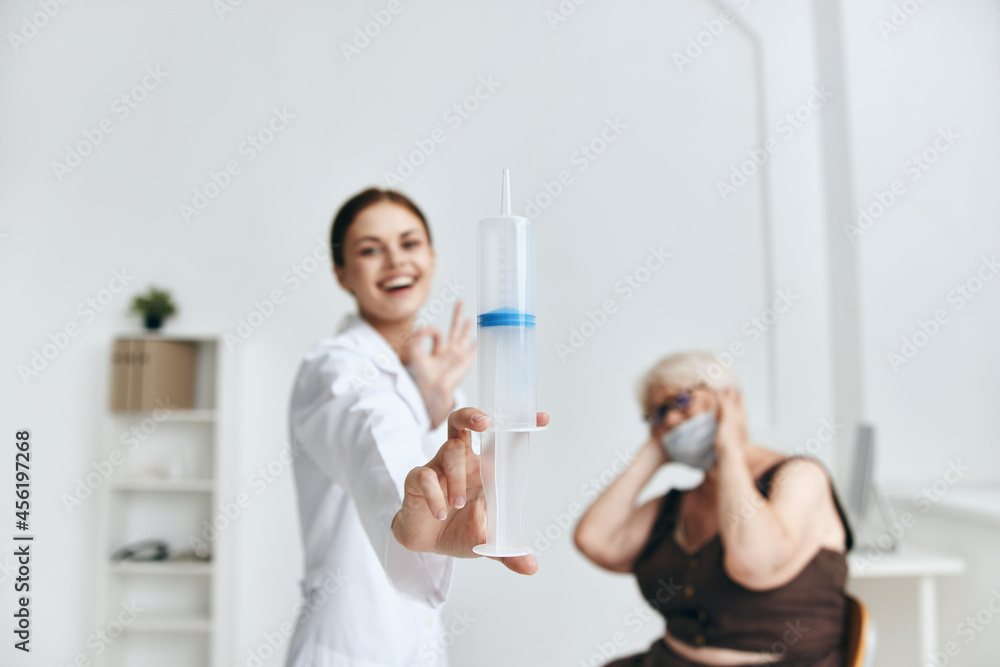 Fototapeta premium Nurse giving injection to an elderly woman vaccination hospital