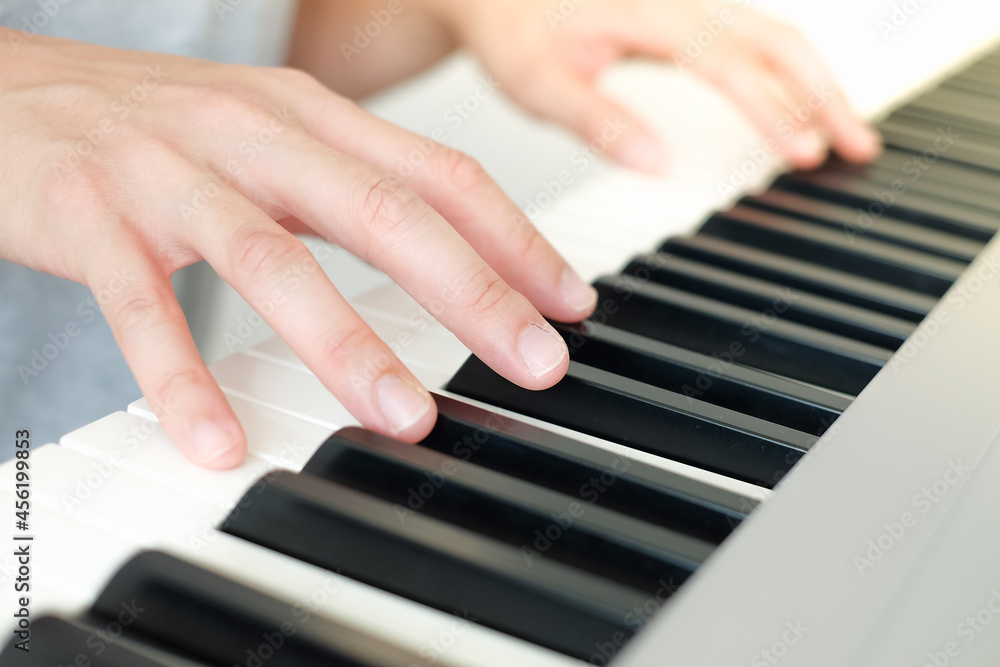 Fototapeta premium Close up man's hand playing piano