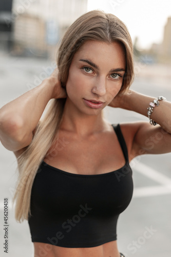 Tela Beautiful young woman in a stylish mockup black T-shirt with a fashion bracelet