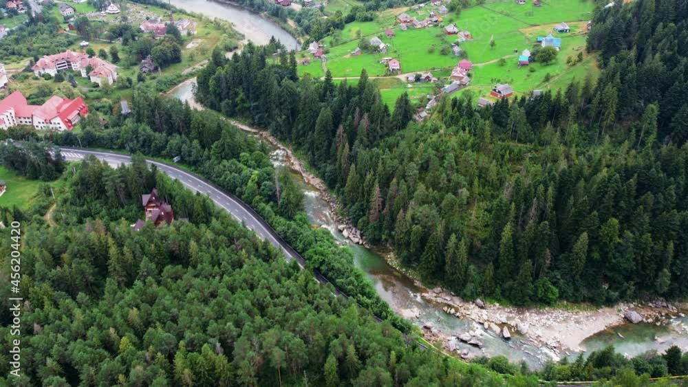 Beautiful aerial view of the road with mountains and forest, road and river, shot from above, carpathians, Ukraine Beautiful aerial view of the road with mountains and forest, road and river, shot from above, carpathians, Ukraine