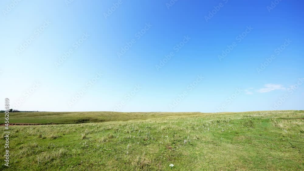 very wide landscape view of ranch land prairie with cattle in the distant horizon very wide landscape view of ranch land prairie with cattle in the distant horizon