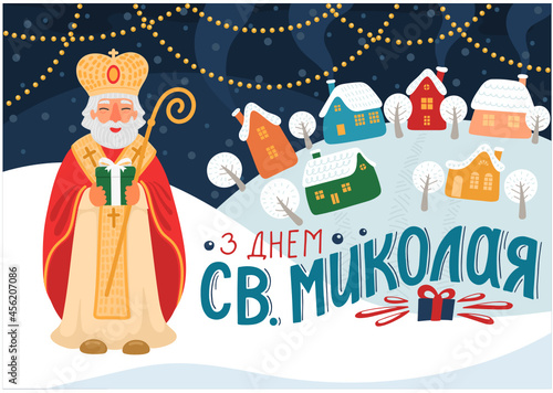З Днем Св. Миколая. Translate:" Happy Saint Nicholas Day". St. Nicolas holding gift in winter village, or city with hand drawn greeting lettering in Ukrainian language. 