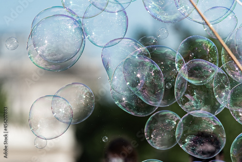 Soap bubbles on a blurred background. Lots of rainbow bubbles connecting with each other. The abstract background.