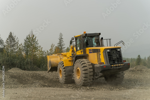 The loader builds the road by working with the bucket.