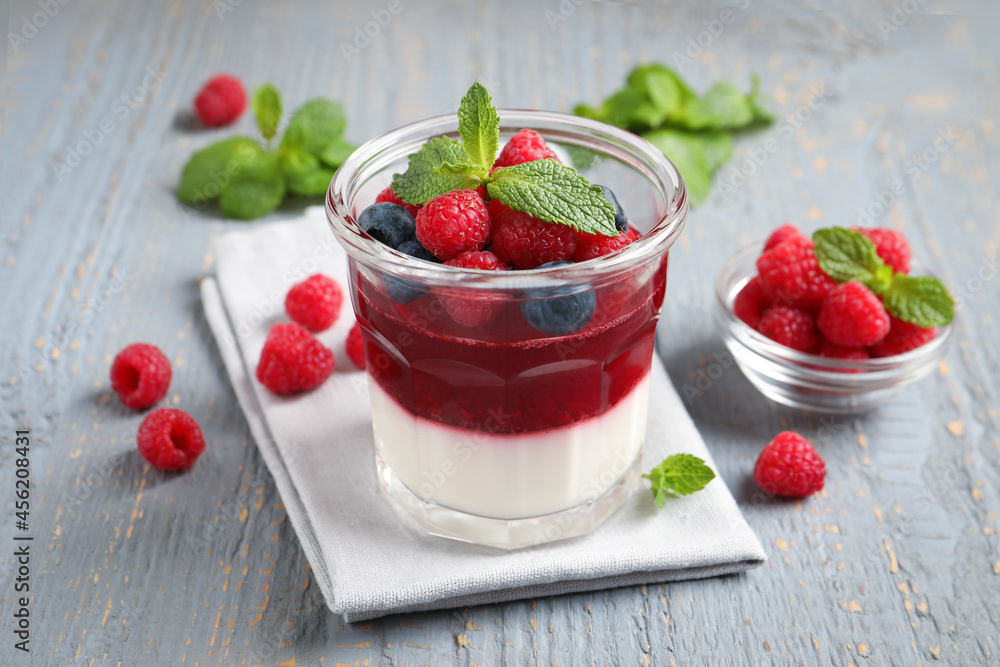 Delicious panna cotta with berries on grey wooden table Delicious panna cotta with berries on grey wooden table