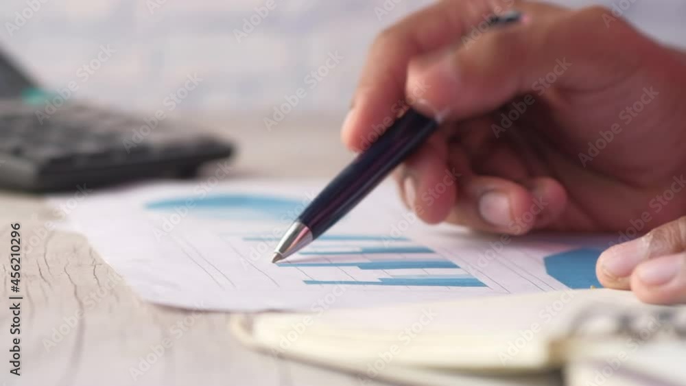 man hand with pen analyzing bar chart on paper man hand with pen analyzing bar chart on paper