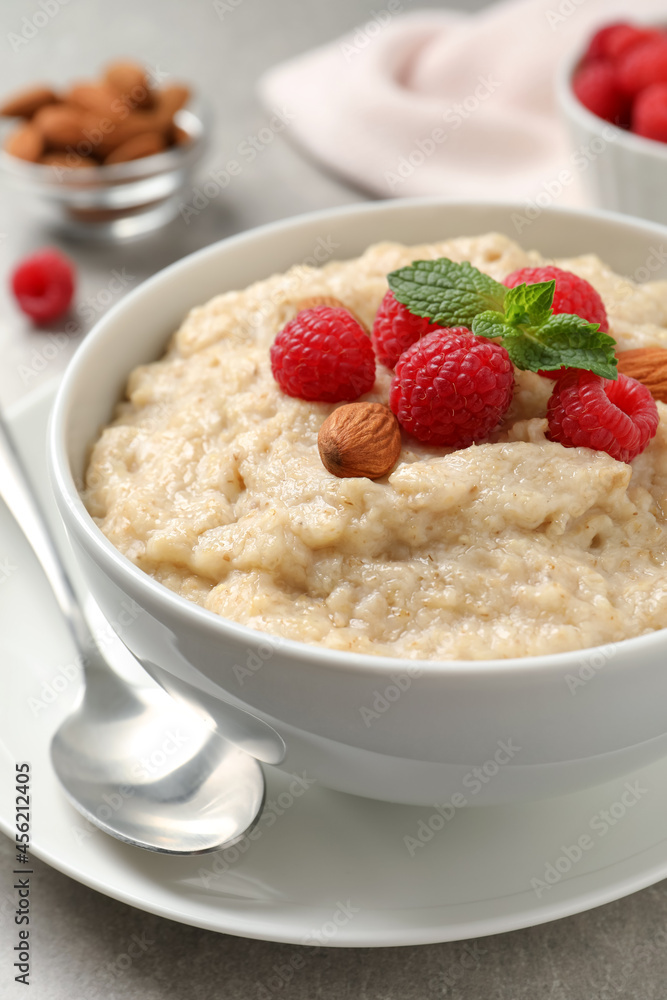 Tasty oatmeal porridge with raspberries and almond nuts served on table, closeup Tasty oatmeal porridge with raspberries and almond nuts served on table, closeup