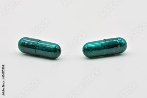 Forma farmacéutica de cápsulas verdes, aislado sobre fondo blanco photo